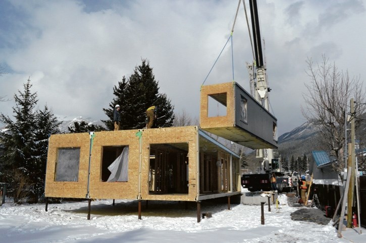 Clockwise from top: a sea can modular housing unit being installed in the community of Exshaw in February.