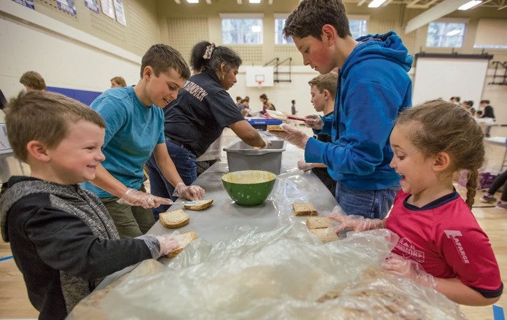 Kindergarten through Grade 9 students help put together sandwiches for the homeless at Our Lady of the Snows Catholic Academy in Canmore on Thursday (May 18). Students