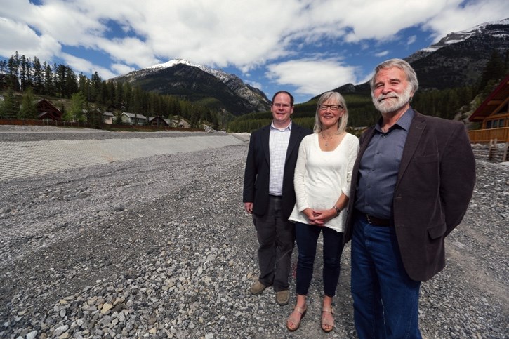 Banff-Cochrane MLA Cam Westhead, left, Canmore CAO Lisa de Soto, and Canmore Mayor John Borrowman stand next to Cougar Creek in Canmore on Friday (May 26). The province