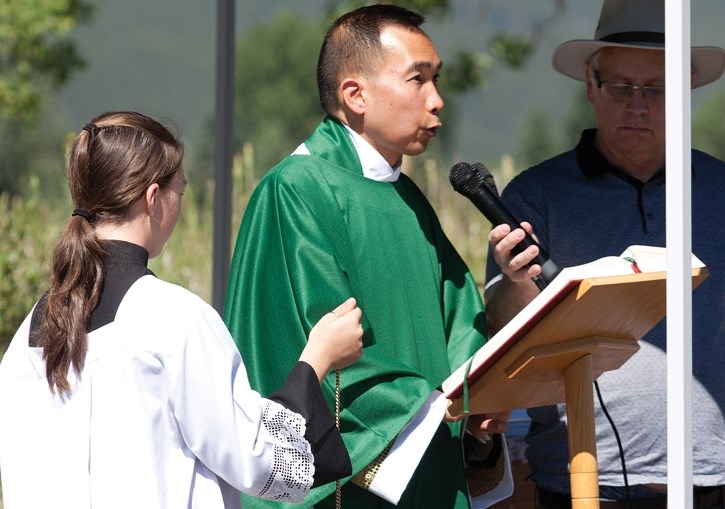 Father Wilbert Chin Jon leads parishioners through an outdoor mass to celebrate the groundbreaking of the planned 25,000 square foot, 500-seat church on Sunday (June 25).