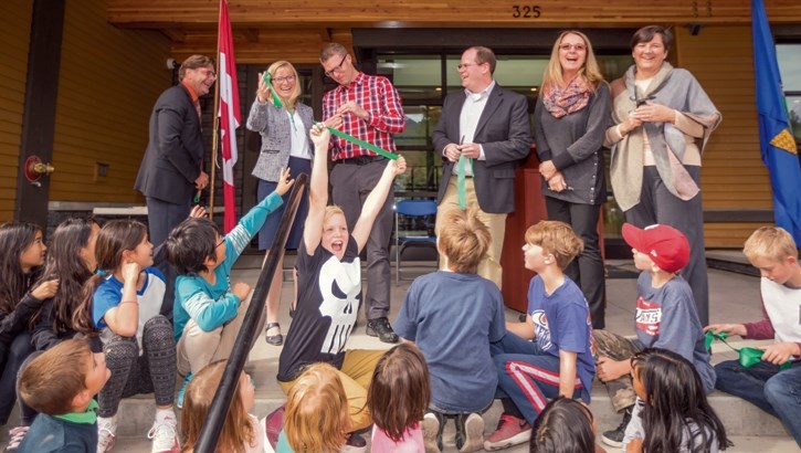 Zach Sunderland, centre, holds up a piece of the ribbon marking Banff Elementary Schools phase one construction officially opened on Tuesday (Sept. 26).