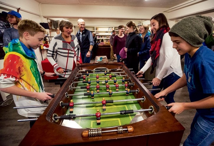 Wyatt Maclean, left, Lorraine Widmer-Carson, Corrie DiManno and Aidan Rutly play some foosball at the official opening of the Banff Canmore Community Foundations The