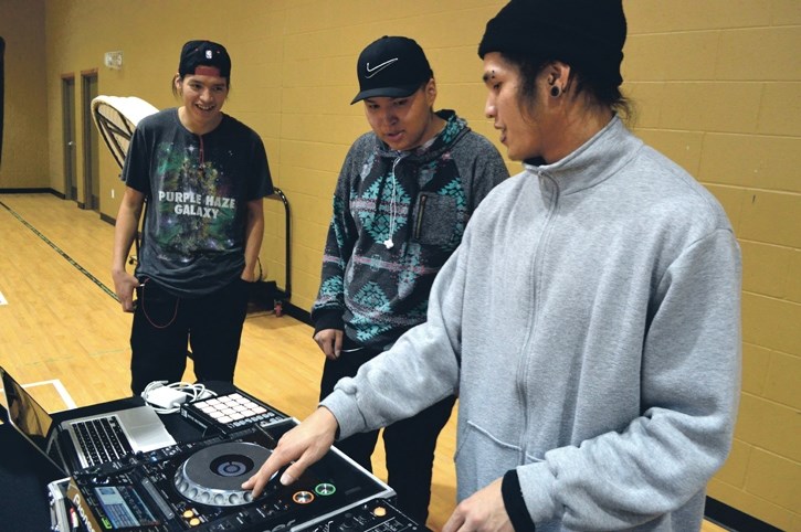 Gene ‘Gomo’ Cabarroguis, right, shows how to scratch and make beats using a turntable to Stoney Nakoda’s Dace Hunter and Kevin Fox at the Morley’s ReFreshed After-School Hip