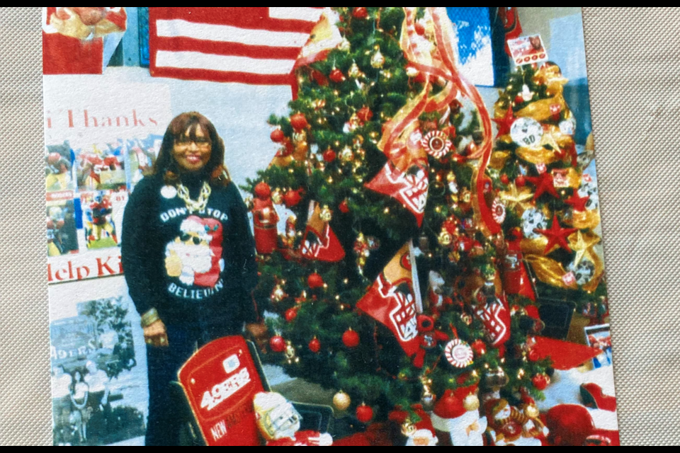 Carolyn Hoskins poses with the 49ers-themed tree at the NFL Alumni Annual Toy Drive