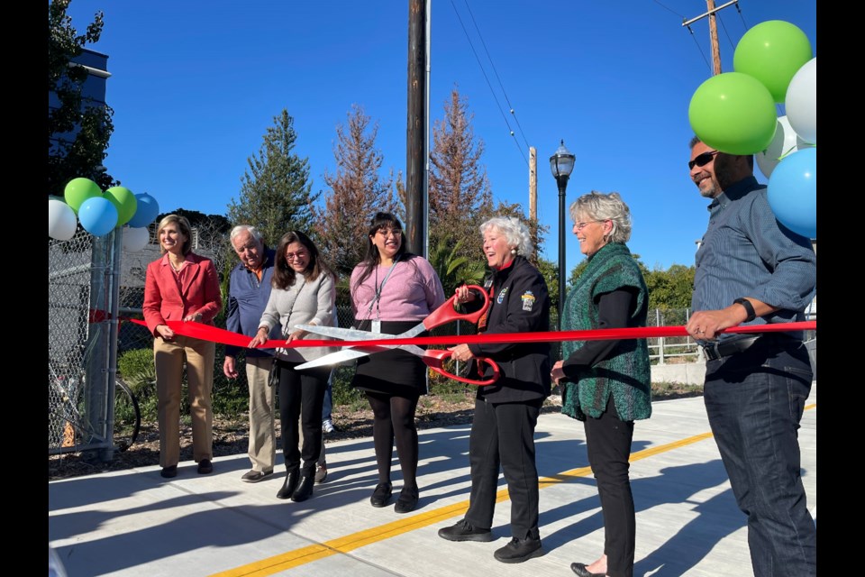 Mayor Diane Howard is joined by city council members and former mayor Ian Bain for the official ribbon-cutting ceremony.