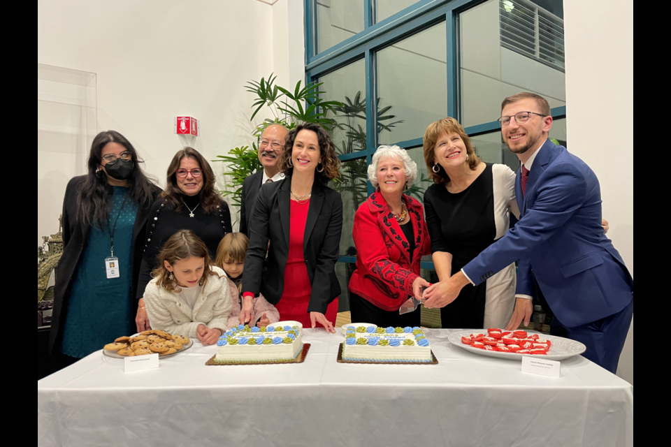 Incoming and outgoing council members cut cake before the city council meeting Dec. 12, 2022