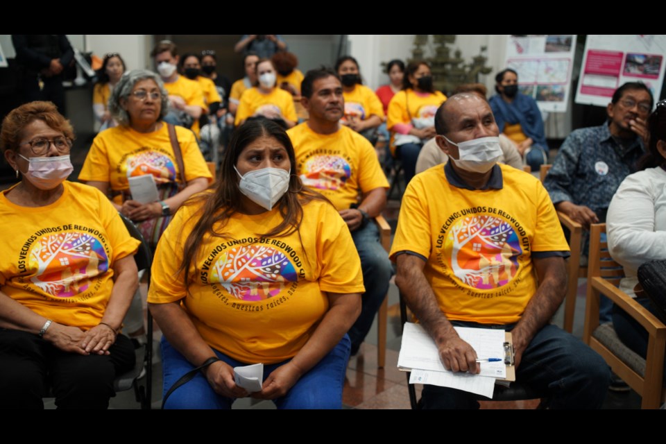 Members of Faith in Action listen to tenants' testimony from overflow seating in the lobby of city hall 