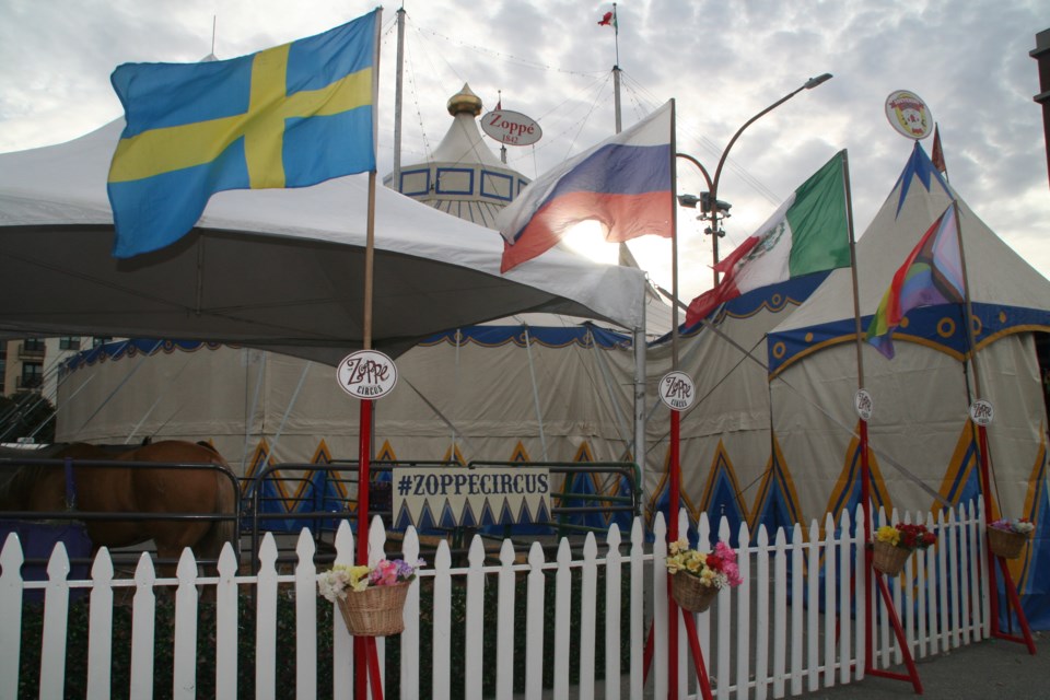 Flags of all colors fly in front of the tent for the annual Zoppé Family Circus.