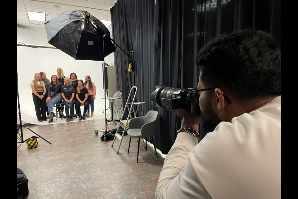 Students in Richard Beland’s photography course at Lambton College are marking International Women’s Day by taking photos of female faculty, staff and students and will have them on display Friday.  Here, first year student Dhruv Singhal photographs the women of the college’s facilities department.
