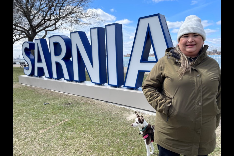 Resident Sara Duque and pup Meghan pose for a photo in front of the new SARNIA sign along the waterfront.