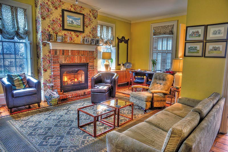 A view of the living room, featuring one of three original fireplaces.