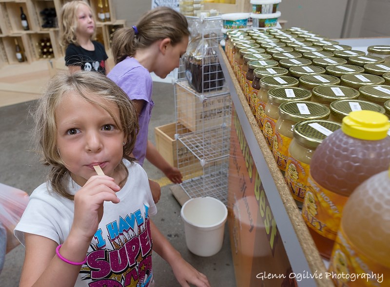 Olivia Ryan, 6, tastes a sample of Twin Bridge Honey at the Sarnia Farmers' Market, with sisters Lexie, 6, and Bella, 8, the children of Kevin and Trish Ryan, of Sarnia.
