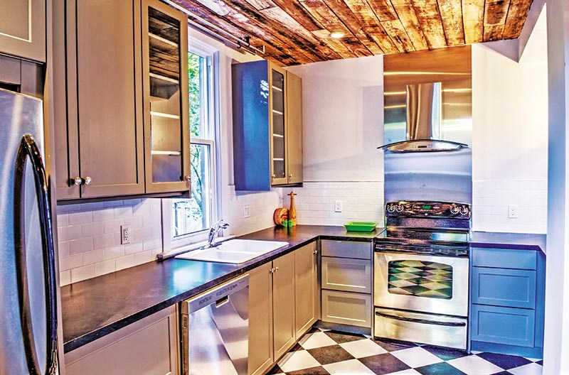 The overhauled kitchen has been opened up with a ceiling finished in recycled lumber. Glenn Ogilvie