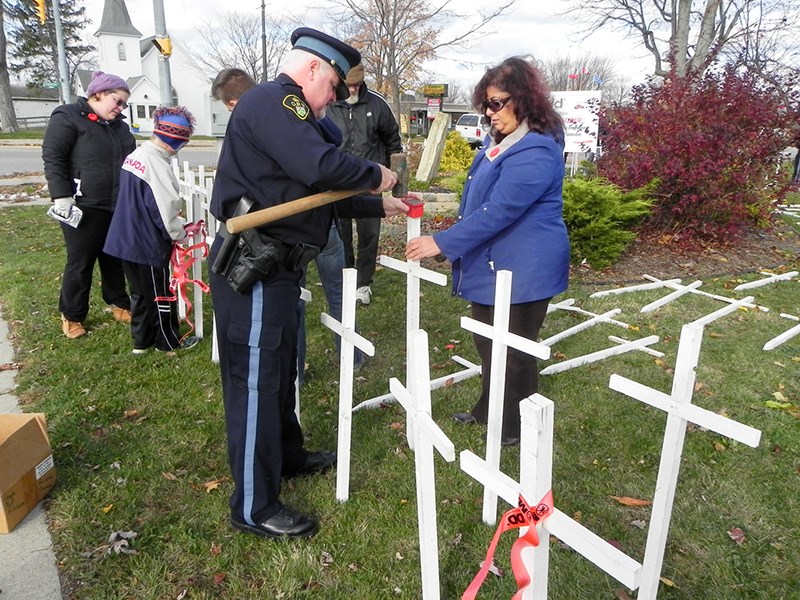 OPP Sgt. Tim Ives worked with employees of Allstate and other volunteers to install crosses.