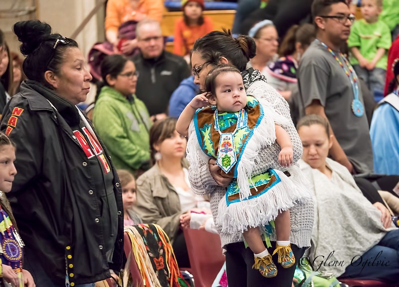 Little Chenoa Plain watches dancers  while being held by his mom, River Jacob Plain, at the Lambton College Aboriginal Cultural and Learning Centre. Glenn Ogilvie