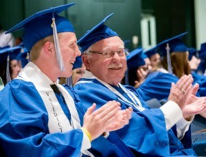 Valedictorian Daniel Marr and fellow graduate 84-year-old Reginald Learn respond to being congratulated by principal Sean Keane during SCITS commence ceremonies on June. 9. 