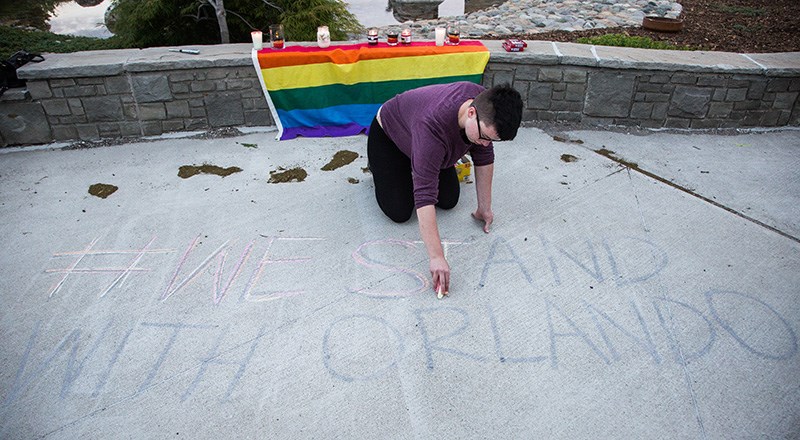 Sarnia resident Xavier Hawkes writes out the hashtag “We Stand With Orlando” at Sarnia's city hall on Monday. Troy Shantz