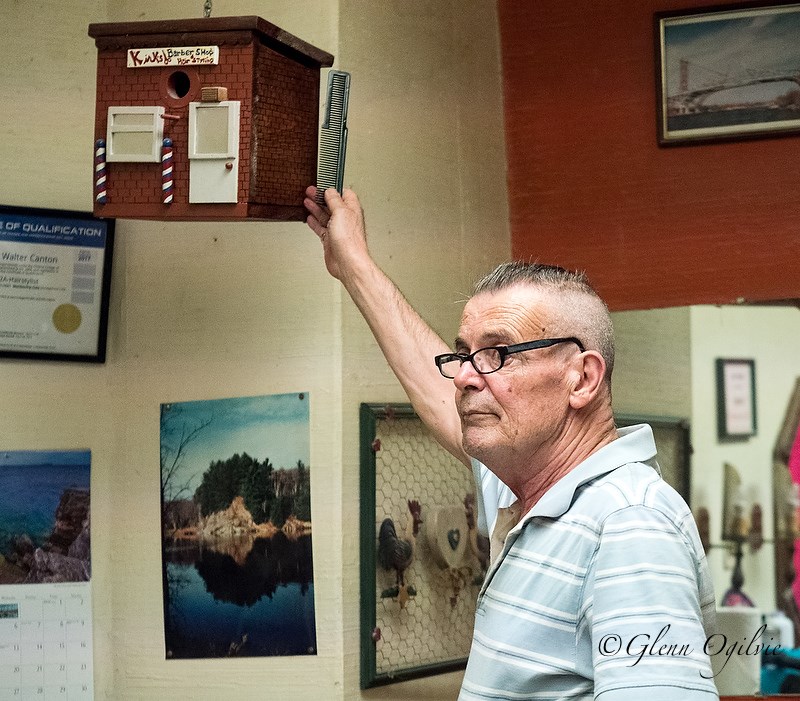 Jim Canton points to some of the memorabilia that decorates the walls of Kirk's Barbershop. Glenn Ogilvie