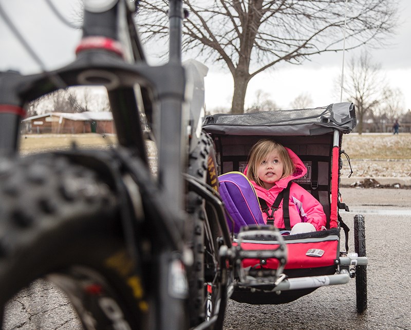 Three-year-old Scarlett sits in her bicycle-trailer that her father Richard Taylor tows daily behind his fat bike. Troy Shantz