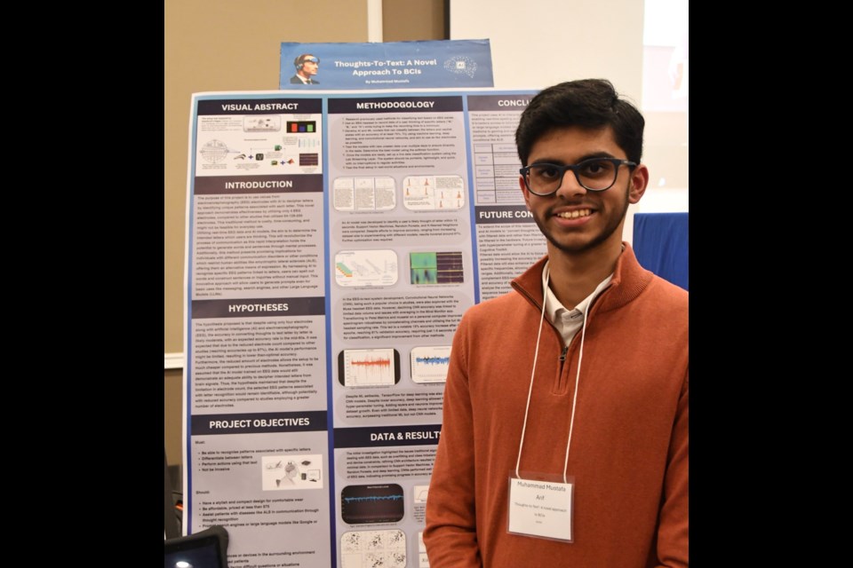 Muhammad Mustafa Arif posing with his 'Thoughts-To-Text: A Novel Approach to BCIs' project entry.