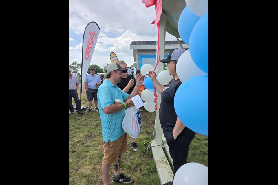 One of the final five qualifiers of the Great Bin Giveaway tries to open the lock, which would declare the winner of the 100-ton fertilizer bin.