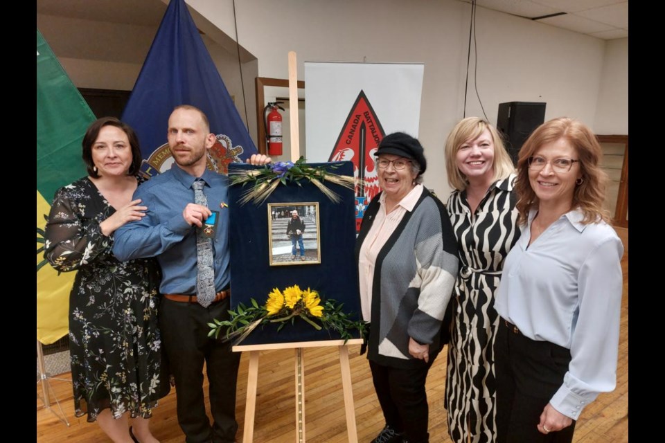 The Hardy family pose around a framed photo of the departed Bud. Sister Marie, brother Will, mother Diane, sister Cristal, and sister Arlene. Photo by Derek Ruttle.