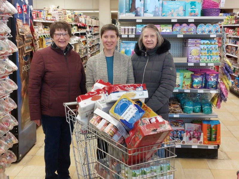 Gail Borsa and Esther Henderson of the Outlook & District Food Bank joined Cara (middle) for a photo after she had 'raided' the store, all for a good cause. PHOTO: Derek Ruttle/The Outlook