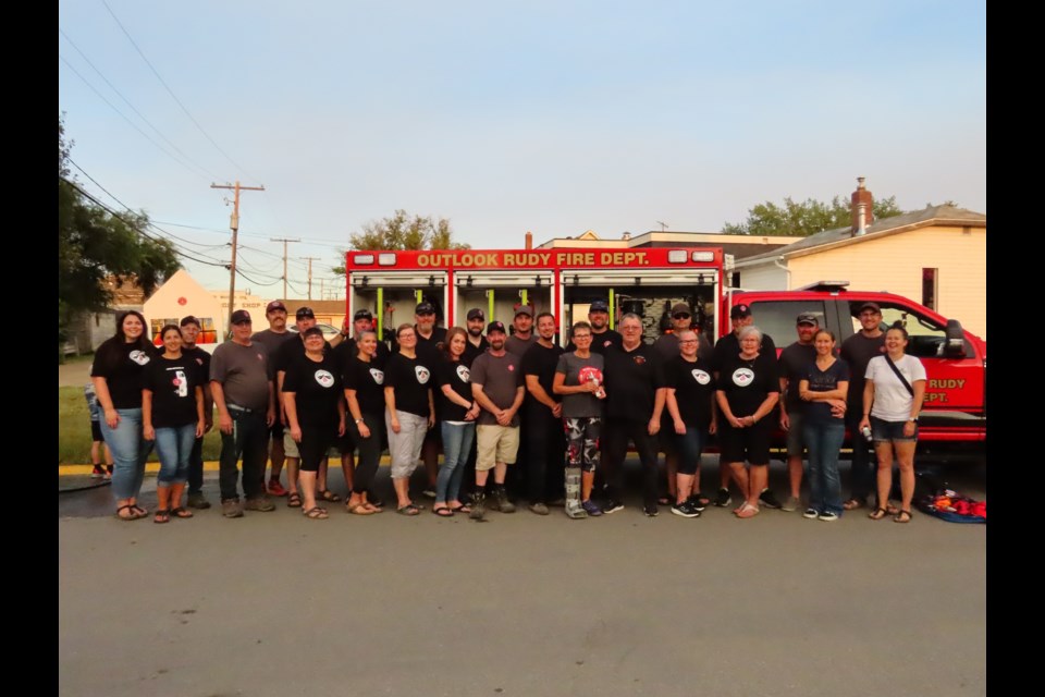 Firefighters and Fireflies posed for a photo in front of one of the trucks. Photo by Derek Ruttle.
