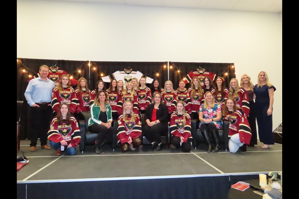 Catriona Le May Doan, Sami Jo Small, and Colleen Sostorics join the Mainline Ice Hawks and staff for a group photo on the stage. Photo: Derek Ruttle/The Outlook