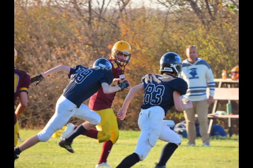 Ball in hand, Outlook #18 Reed Wall tries to evade Plenty #79 Hunter Weese.