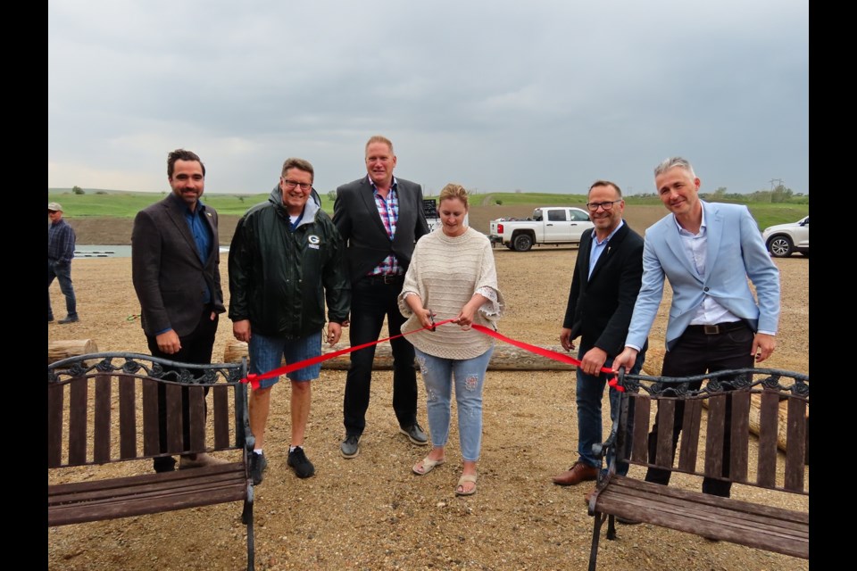 Sandy Shores Resort owner Rauncie Kinnaird is joined by MP Jeremy Patzer, former MLA Eric Olauson, Danielson Provincial Park's Joel Perry, MLA Marv Friesen, and Minister of Environment Dana Skoropad in cutting the ribbon on the new marina development.