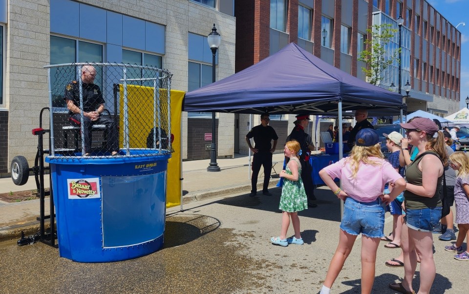 A young girl tries to dunk a volunteer officer in the dunk tank during the Saskatoon Police Service's annual summer barbecue event.