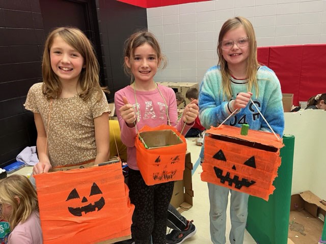 Hannah Petovello, Brynley Maze and Sierra McCubbing show off  Halloween baskets they made on Oct. 20 during Education Week at Unity Public School