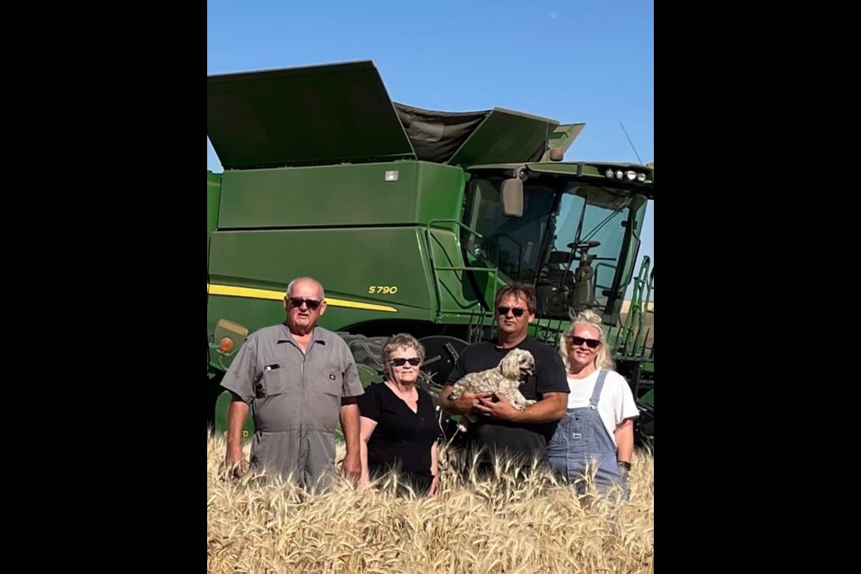 From left, Lorne, Charlene and Kirby Hanson with Holly in his hands and Christine Hanson-Daae during their last harvest in 2021. Christine is wearing overalls that belonged to their little sister that passed away in 2002. 