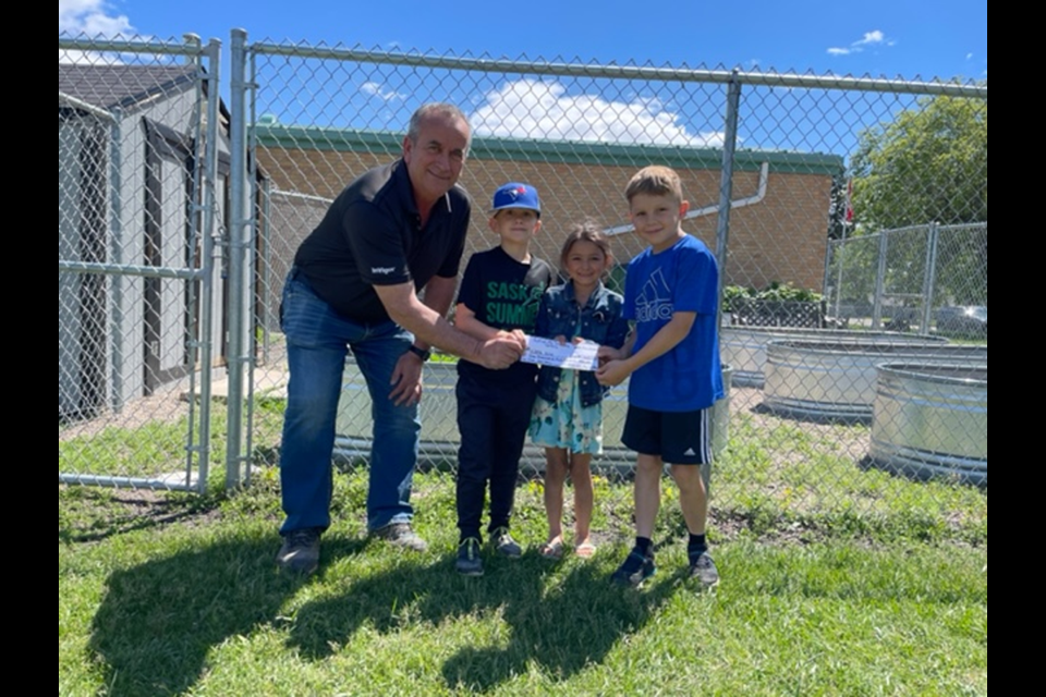 Nick Koroluk of Nutrien presented a cheque to Canora Junior Elementary School for its 2022 garden. Students, from left, were: Jacob Prychak, Keira Owchar and Coy Kraynick, who accepted the funds on behalf of the school.
