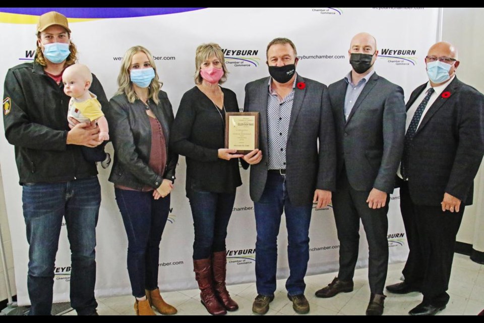 The Golden Sheaf Award was presented by the Weyburn Chamber of Commerce Tuesday. From left are Shawn and Kendall Eggum with son Cooper; Roslyn and Brad Eggum; chamber president Reed Anderson, and executive director Larry Heggs.