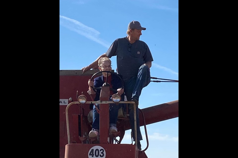 The smile says it all as 90-year-old Muriel Neumeir, accompanied by her son Joe, mans a combine that she once operated on her and her husband's farm.  Neumeier was part of the antique harvest operations at Kerrobert Harvest Festival.