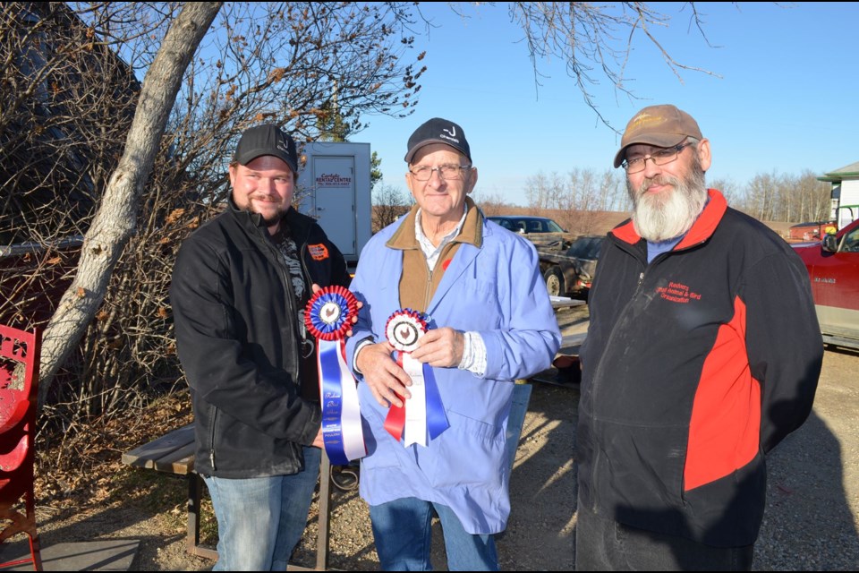 Justin Robertson and Jack Robertson of J&K Call Ducks & East Indies of Amarandh, Man., won awards for both the show champion and reserve show champion. On the right is Rob McCulloch presenting the awards. 
