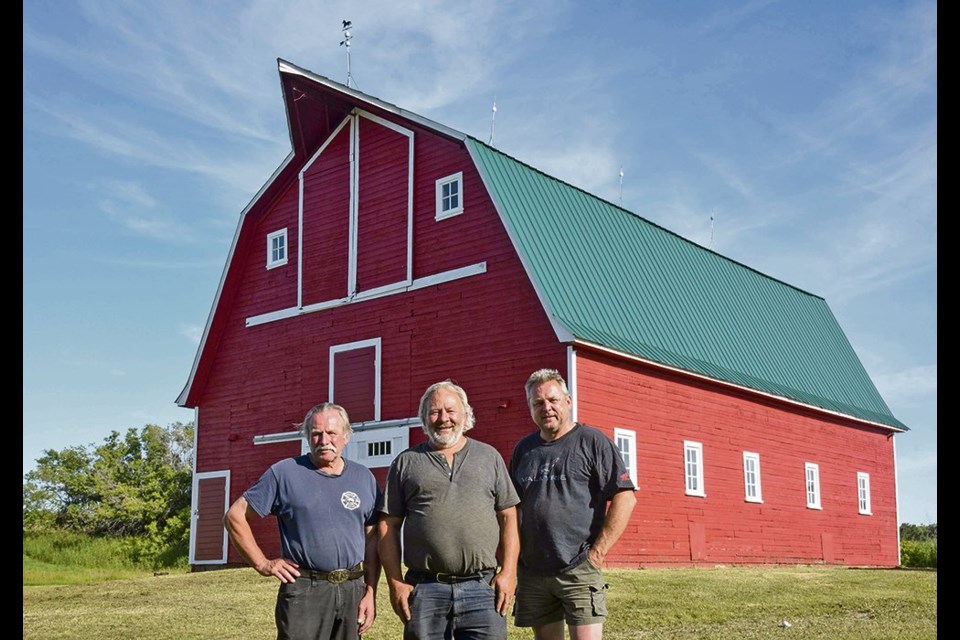 Lorne, left, Brian and Murray Schmid have spent their vacation time during the past 15 years to get the family barn, built in 1935, structurally sound again. 