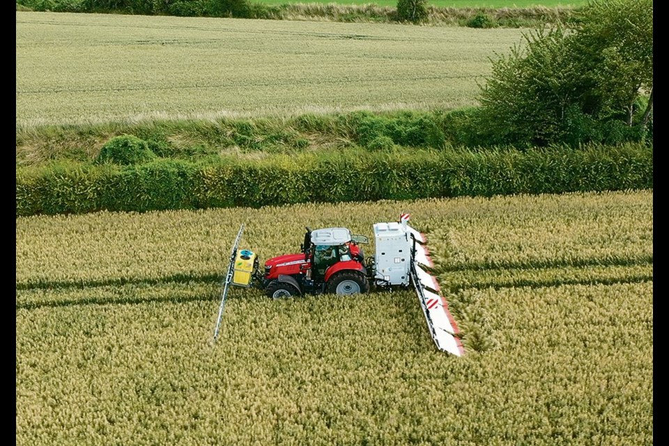 An application of conductive liquid is made ahead of the tractor, while the rear-mounted generator and electrically charged panels do the plant termination at the back end.