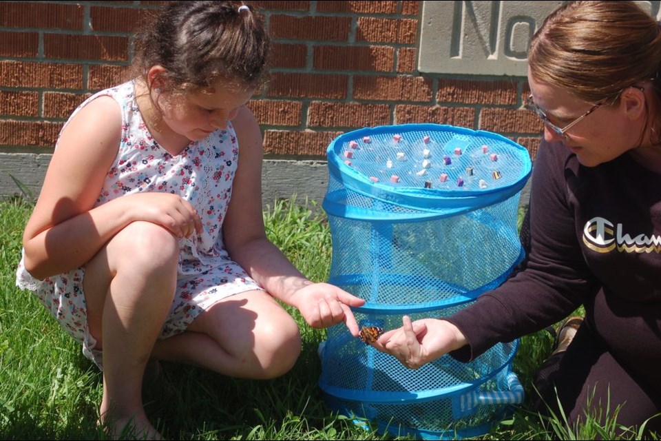 Saying goodbye to the butterflies from left, were Sage Ward and Tonilee Lario, teacher.