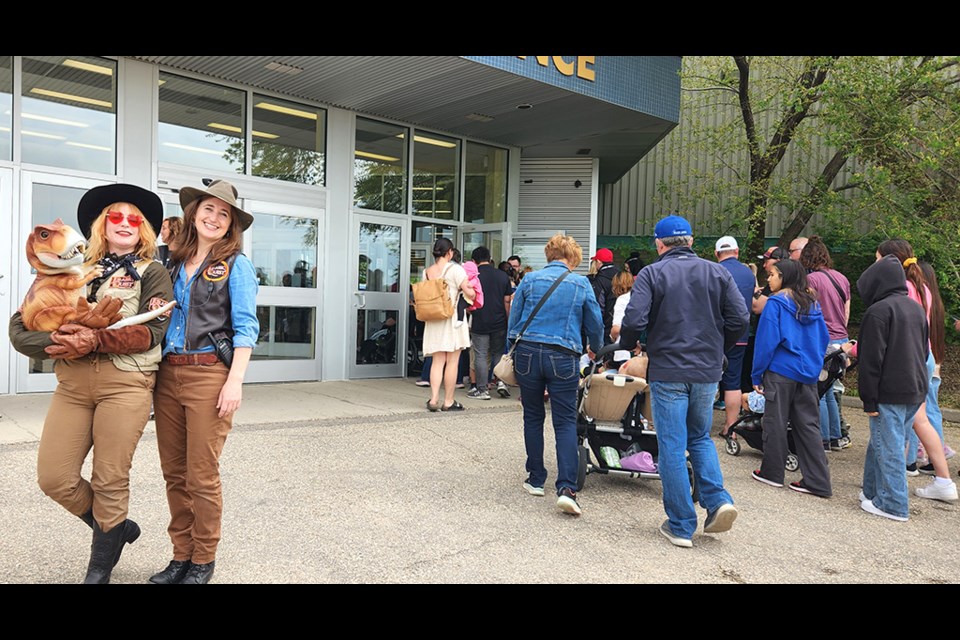 Carolyn Barker, right, and fellow "dino trainer" Anna with baby T-Rex Tyson as they greet the crowd during Jurassic Quest's stop in Saskatoon.