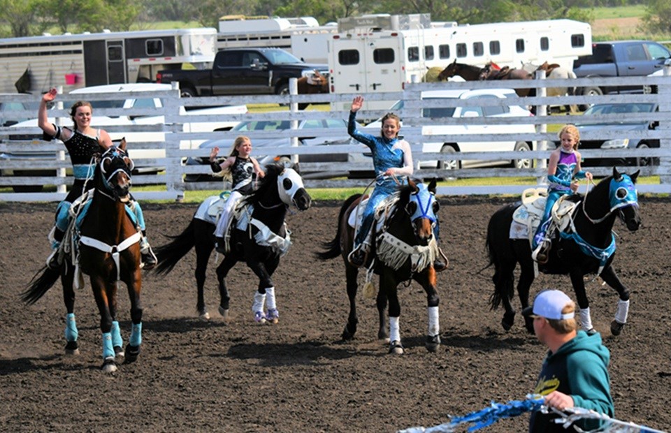 The Grace & Grit trick riders, Shae Worthington on Overtime, Hadley Bacon on Zack, Shelby Bacon on Sizzler and Paisley Bacon on Bart.