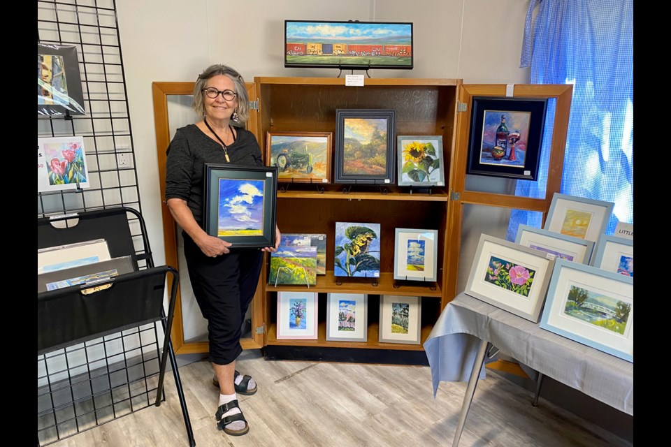 DeLee Grant poses alongside some of her artwork while at the Artist Colony in the Moose Mountain Provincial Park