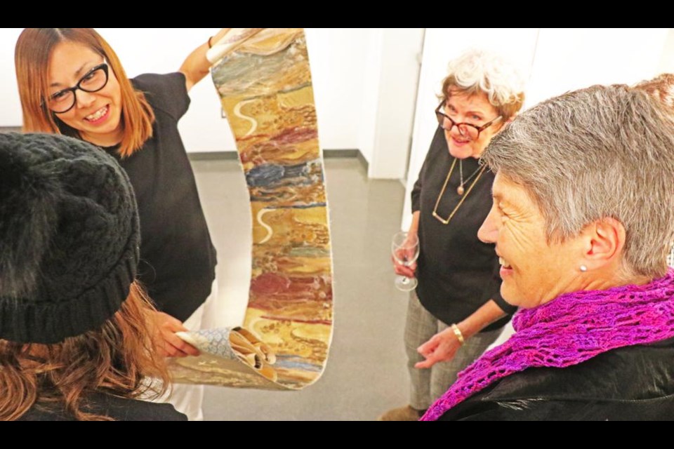 Artist Hanna Yokozawa Farquharson spoke about her exhibition, "Gaia Symphony", and showed the silk materials she used for one of her works to Linda Aitken and Jayne Himsl.