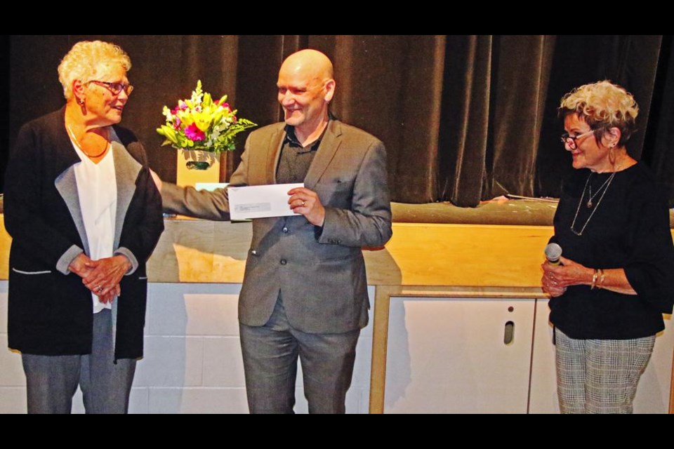 A donation to OSAC was presented by emcee Linda Aitken, right, to Skip Taylor of OSAC, in tribute of Lynn Kot's 46 years of volunteering.