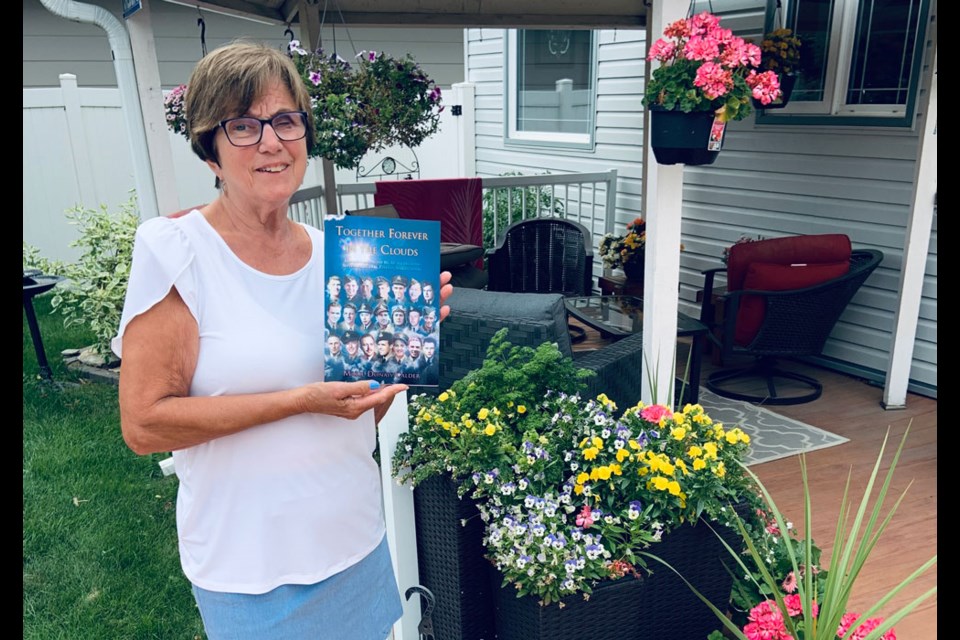 Marie Calder holds a copy of Together Forever in the Clouds, which honours the 21 members of the Royal Canadian Air Force who died in a place crash south of Estevan in September 1946. 
Photo by Marie Calder