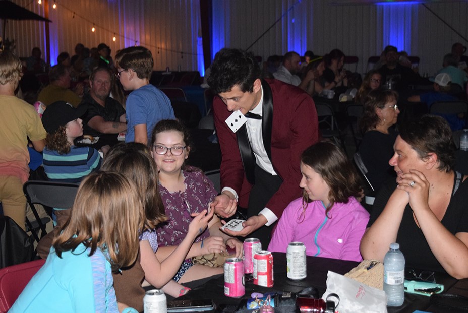 Magic Ben was getting to know the audience well before taking to the stage at Full Moon Friday in Canora on June 2. Here he’s doing card tricks for a table of fascinated young ladies. 