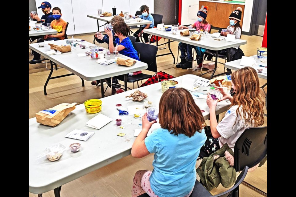 The fun science class participants watch the chemical reactions happen in the "burp in a bag" experiment, during the "Eww, that science is gross!" class on Saturday morning at the CU Spark Centre