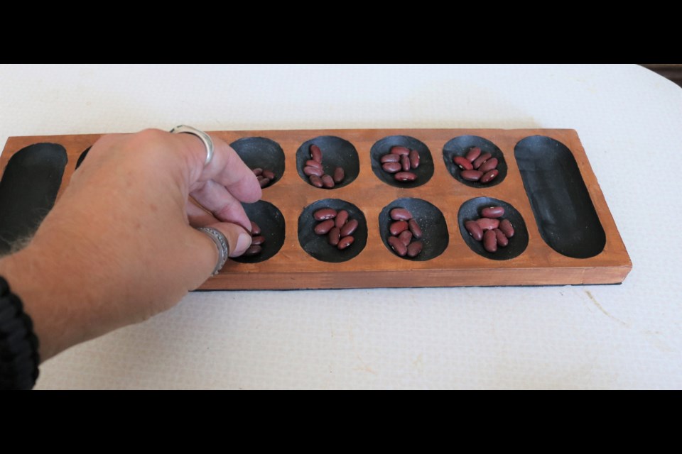 There are a number of games in the mancala family with use a board of pits with plays moving beads or beans or shells around the board.